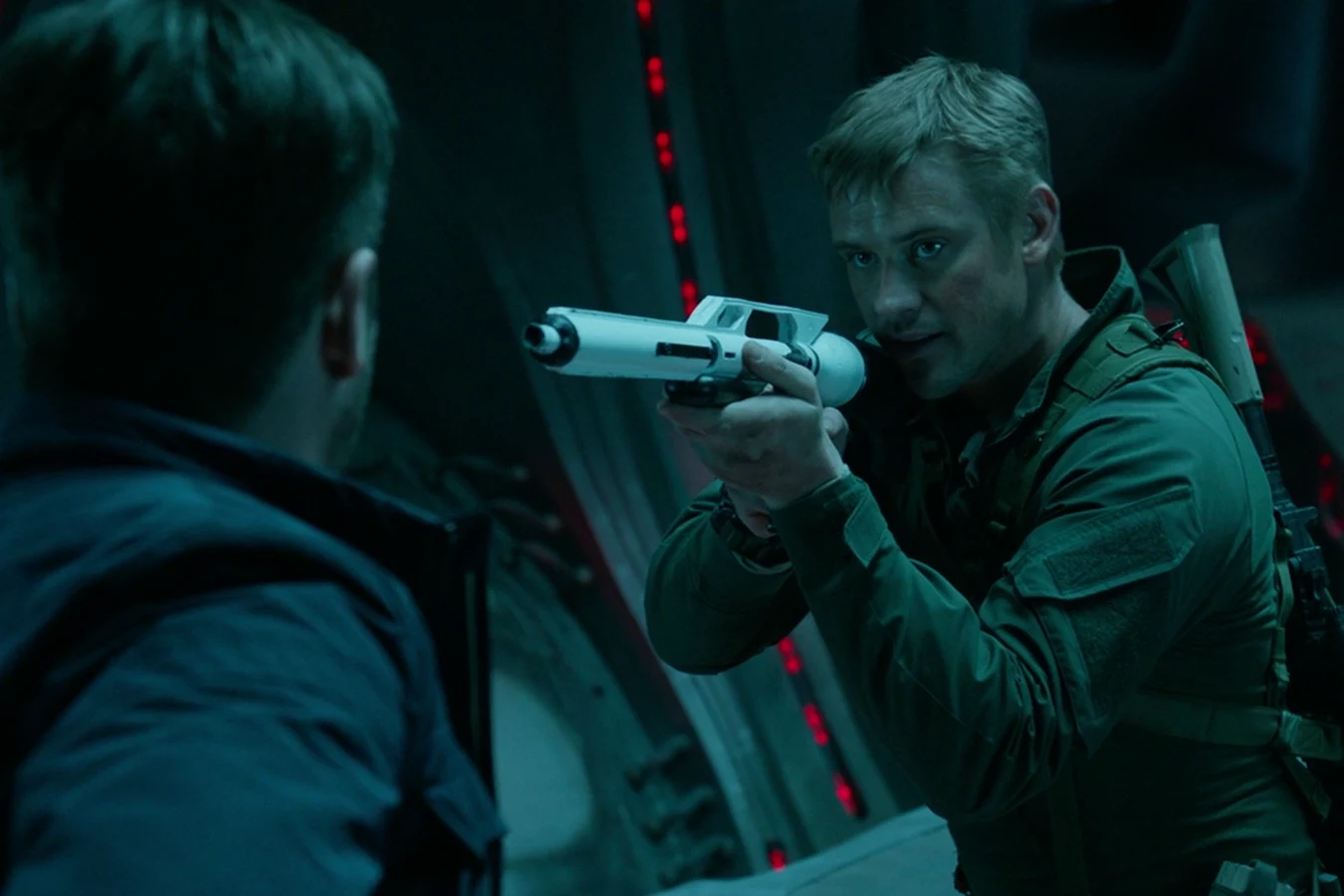 Quinn McKenna aiming a tranquilizer rifle