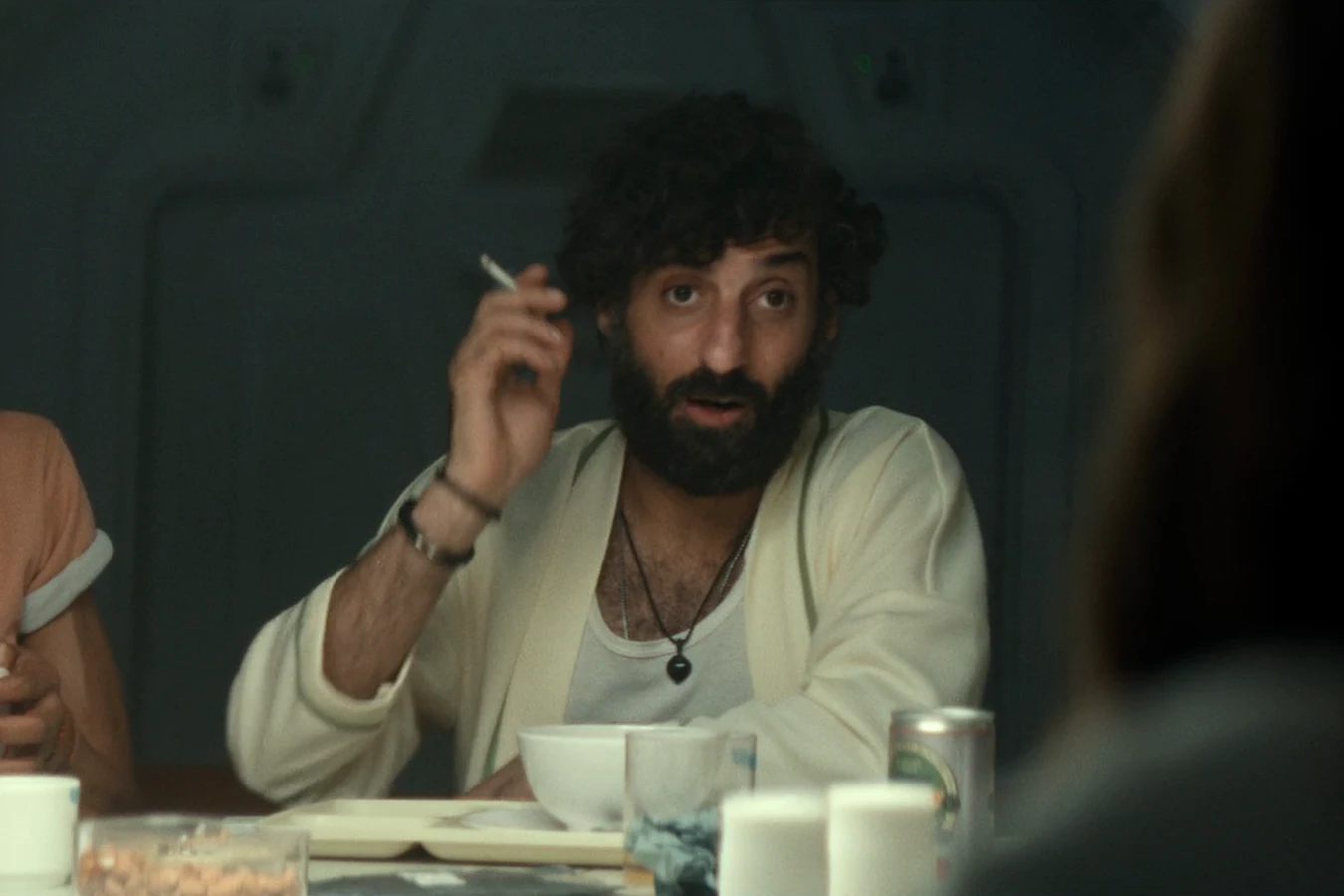 Rahim smoking at the Maginot mess table after waking from cryo in Alien: Earth