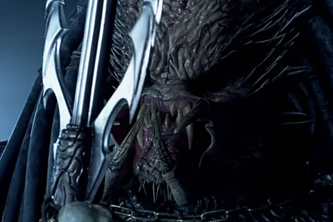 An Elder Predator offering a ceremonial spear trophy in Alien vs. Predator