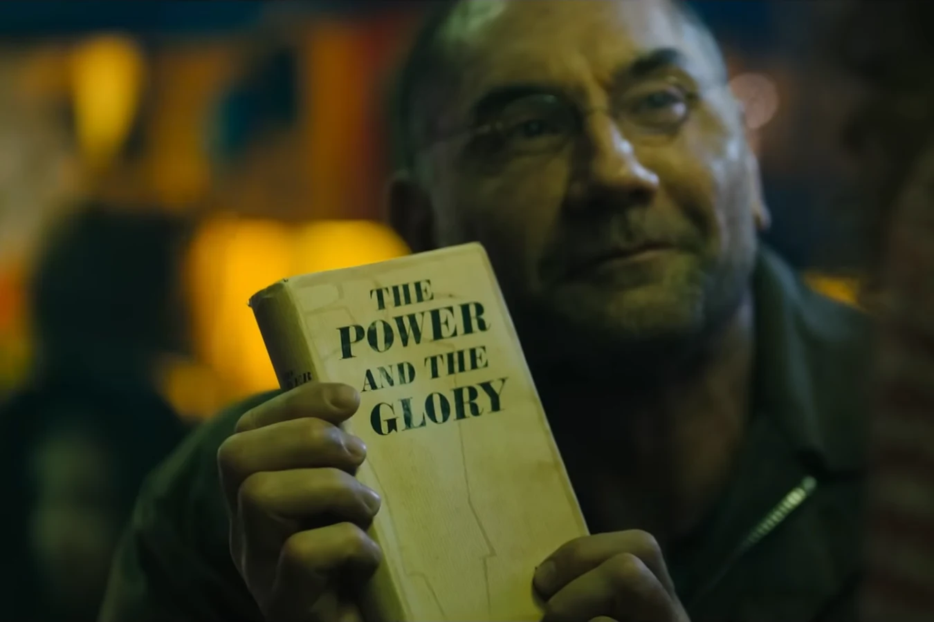 Sapper Morton holding a copy of The Power and the Glory in 2048: Nowhere to Run