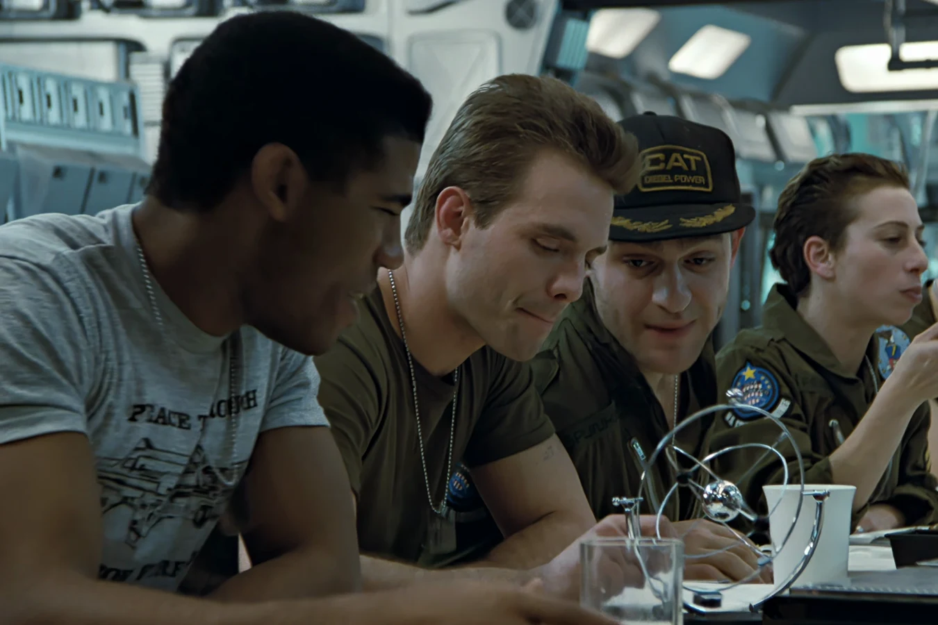 Frost at the Sulaco mess table in a PEACE THROUGH SUPERIOR FIREPOWER T-shirt, with Hicks, Spunkmeyer, and Dietrich