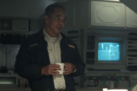 Captain RJ Dinsdale in his Maginot jacket in the mess hall in Alien: Earth