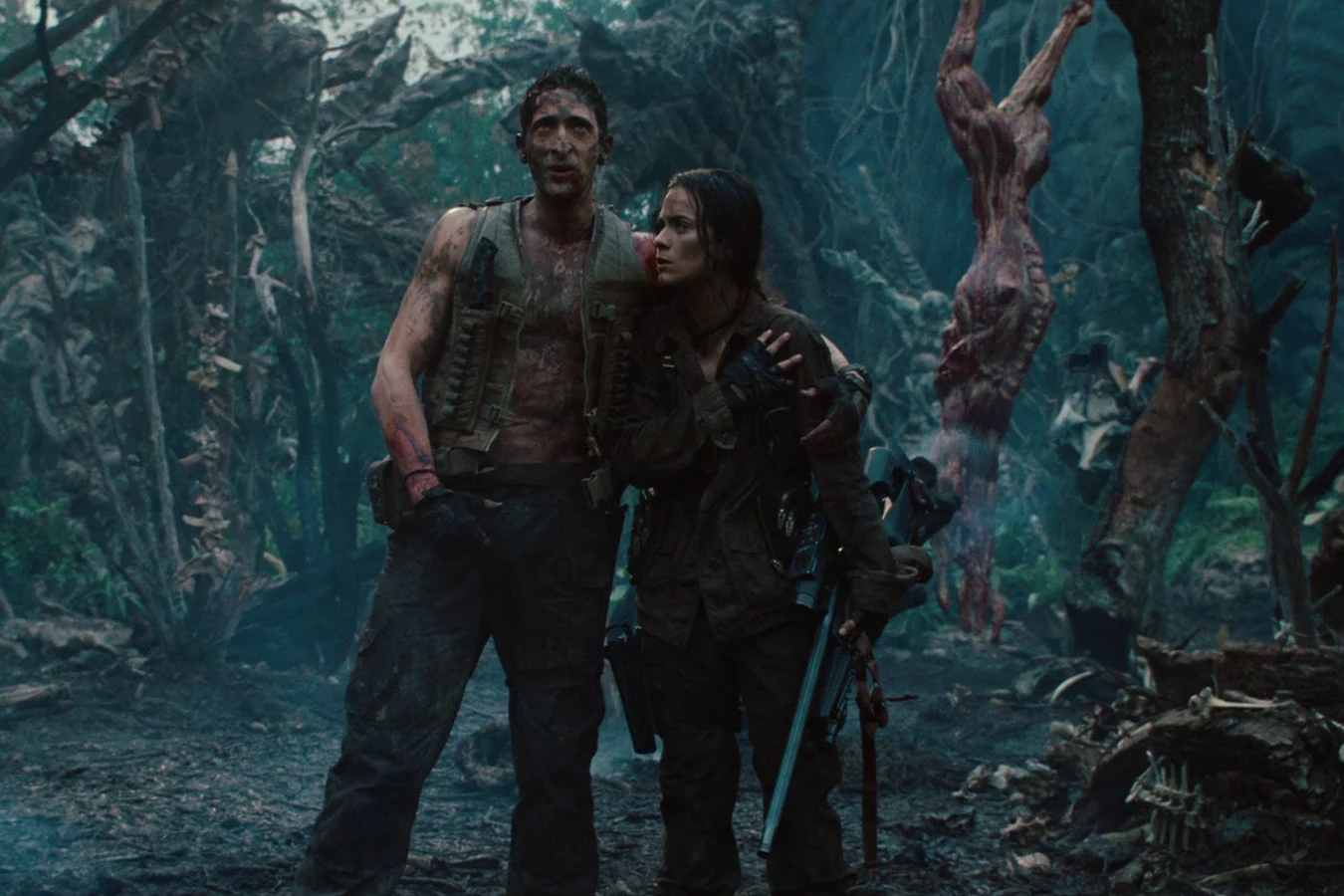 Royce and Isabelle standing together at the hunters' camp after the fight, with a skinned carcass hanging beside them