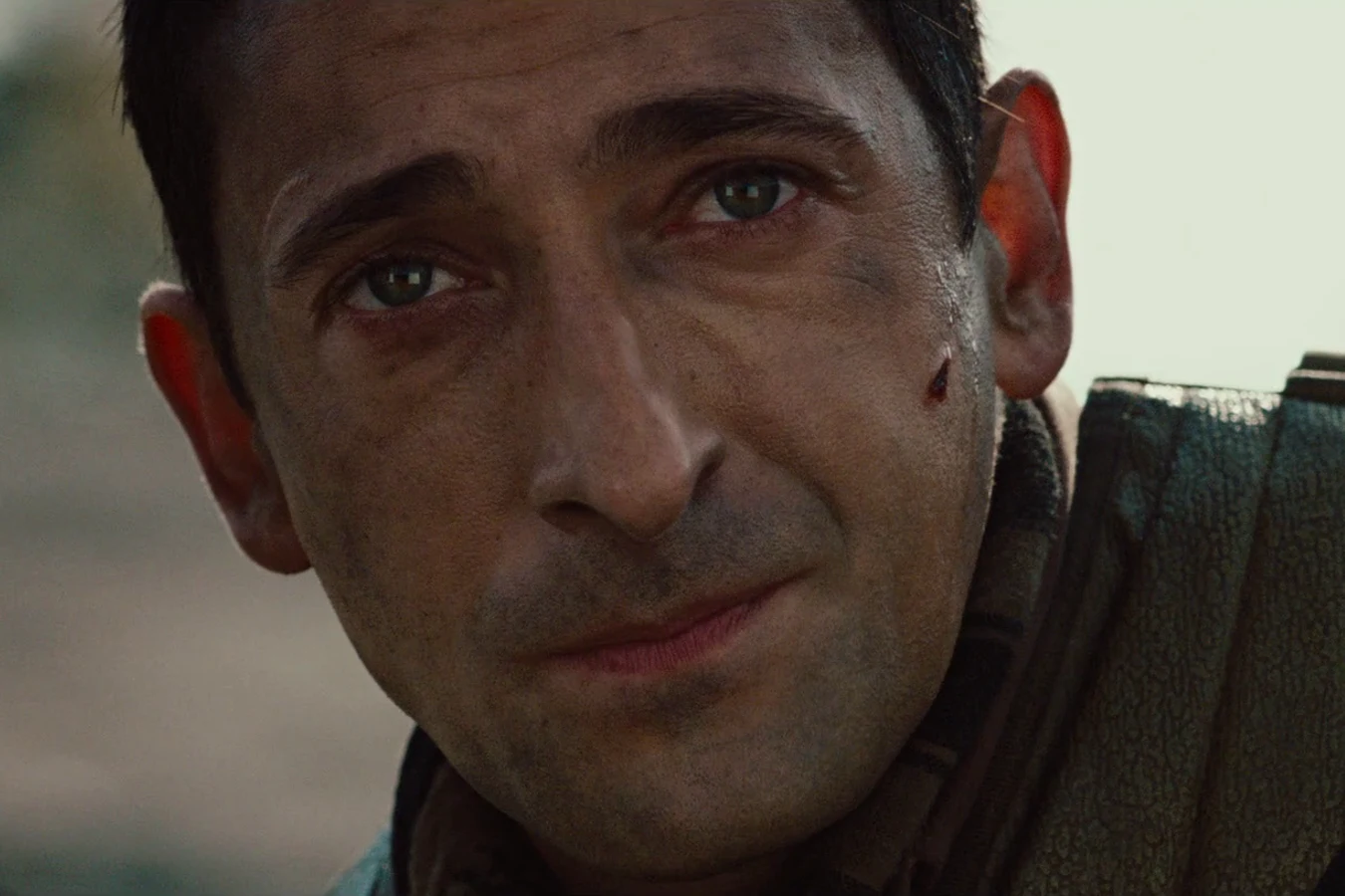 Close-up of Royce with a cut on his cheek, looking toward someone off to the side