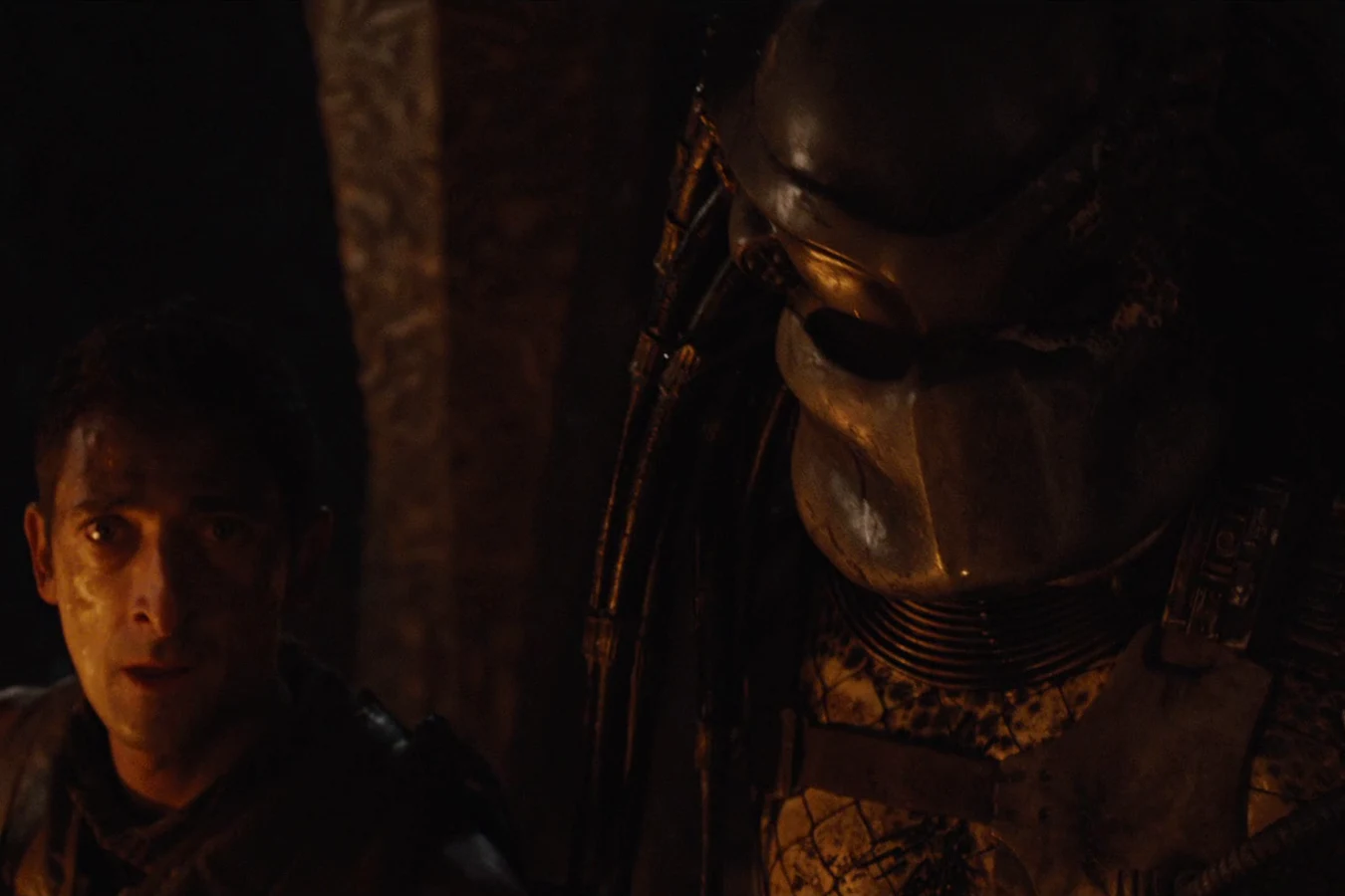 Royce in the dark beside the masked Crucified Predator at the hunters' camp