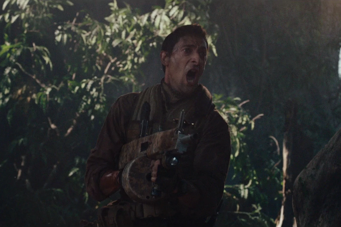 Royce shouting in a dark jungle with his drum-fed AA-12 shotgun held across his chest