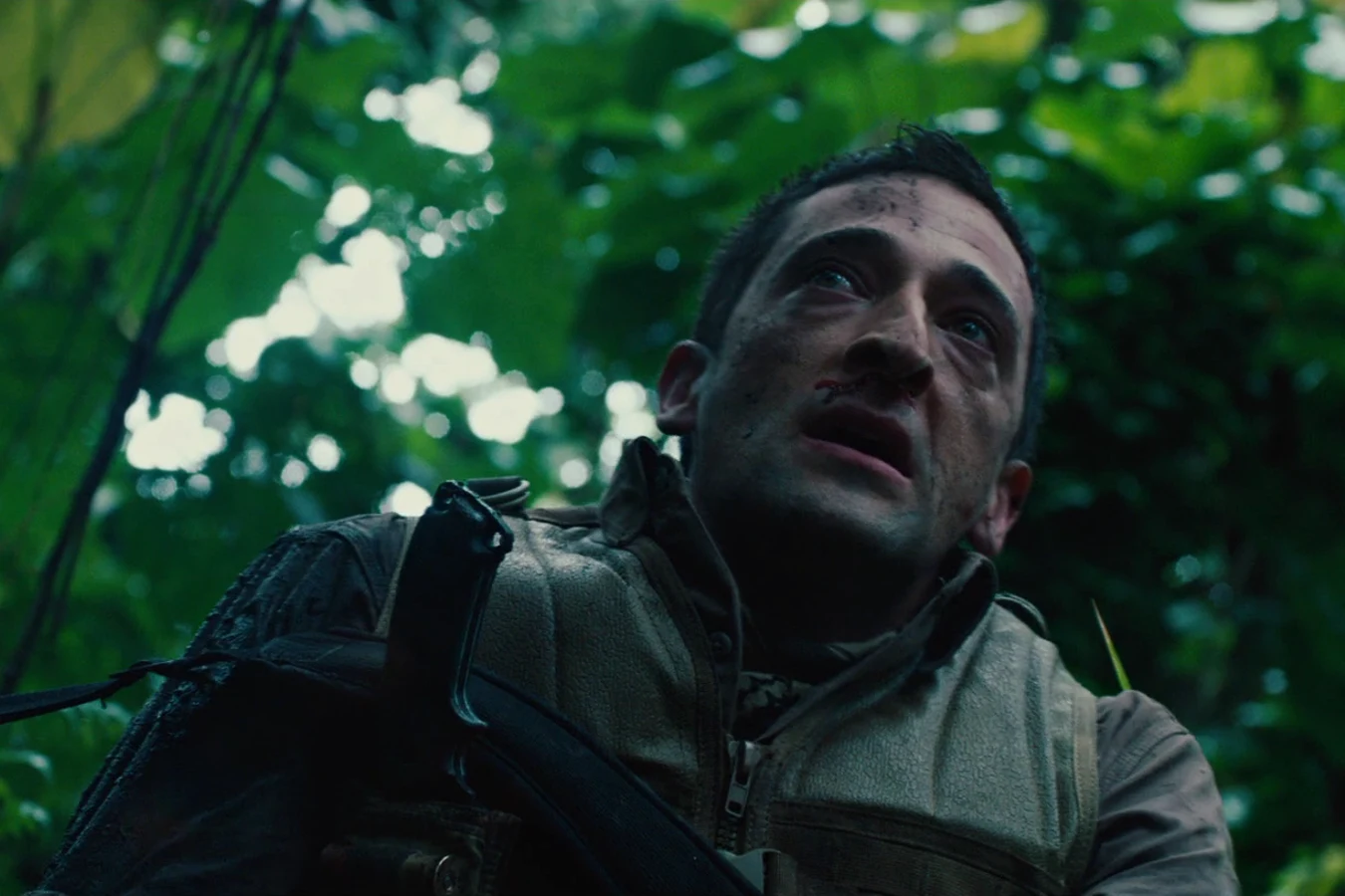 Royce looking up through the leaves of a green jungle after landing on the Game Preserve Planet