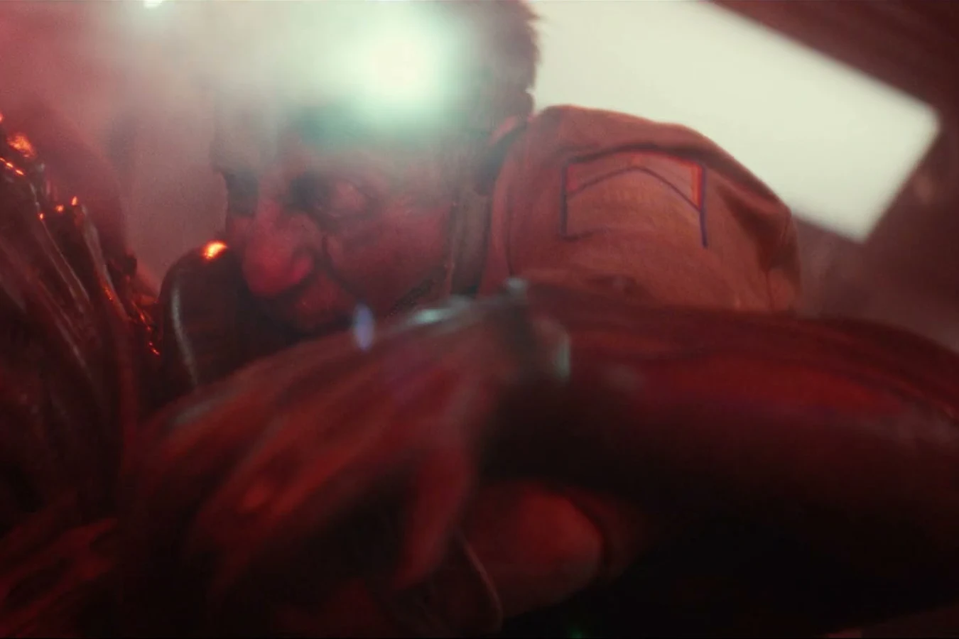 Shmuel locked in a fight with a Xenomorph under red Maginot emergency light in Alien: Earth
