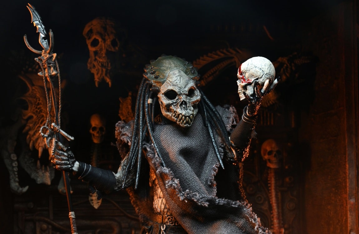 Shaman Predator wearing a skull mask and holding a skull by NECA