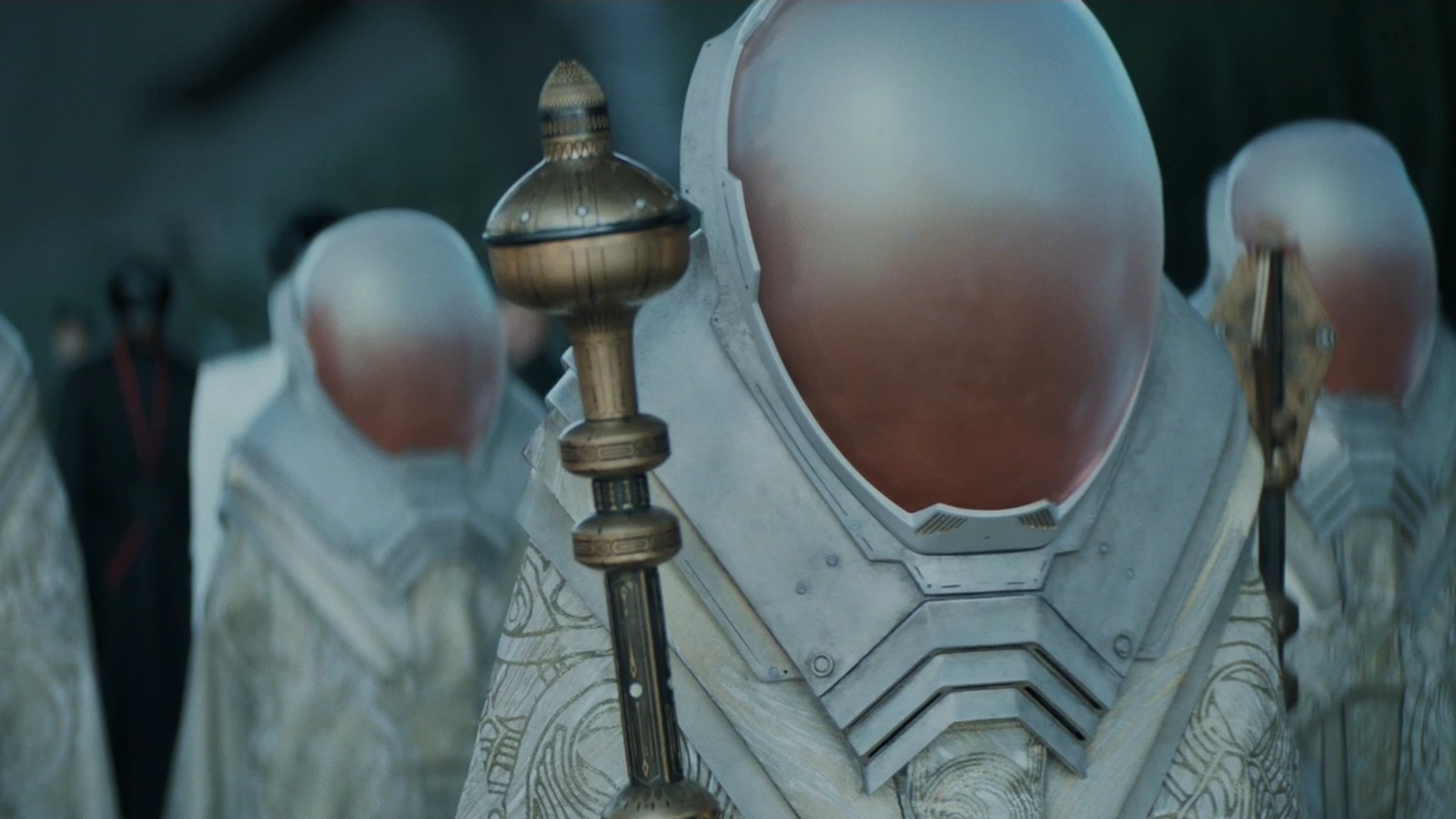 Spacing Guild representatives in ornate white robes and tall helmets with opaque visors