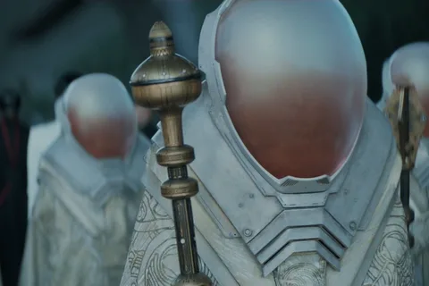 Spacing Guild representatives in ornate white robes and tall helmets with opaque visors