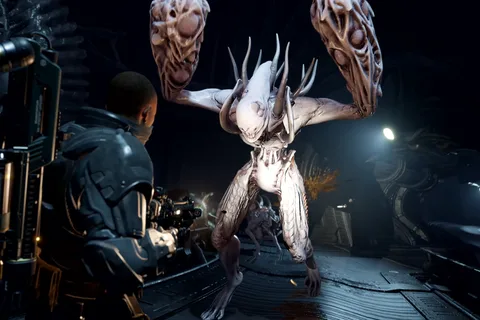 A Colonial Marine firing on a Striker pathogen creature in a dark corridor in Aliens Fireteam Elite 2