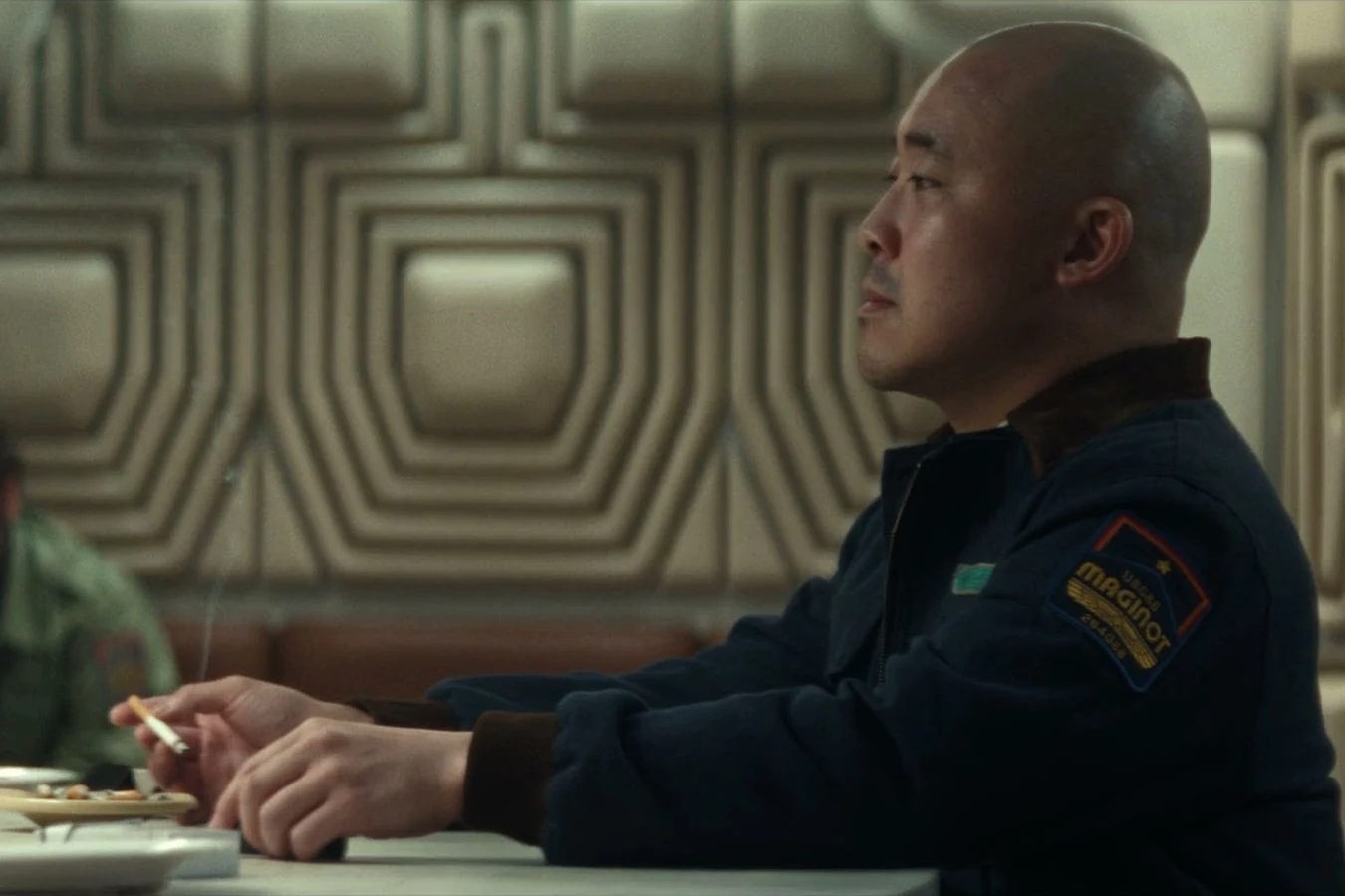 Teng smoking at the Maginot mess hall table in Alien: Earth