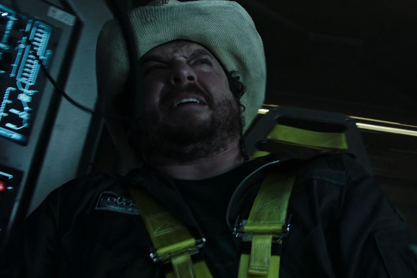 Tennessee in his hat and flight harness, head back and grimacing