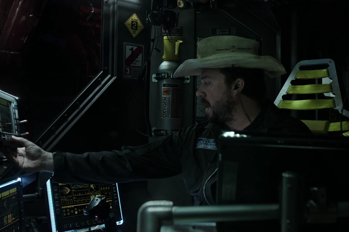 Tennessee in his cowboy hat reaching for an overhead control panel