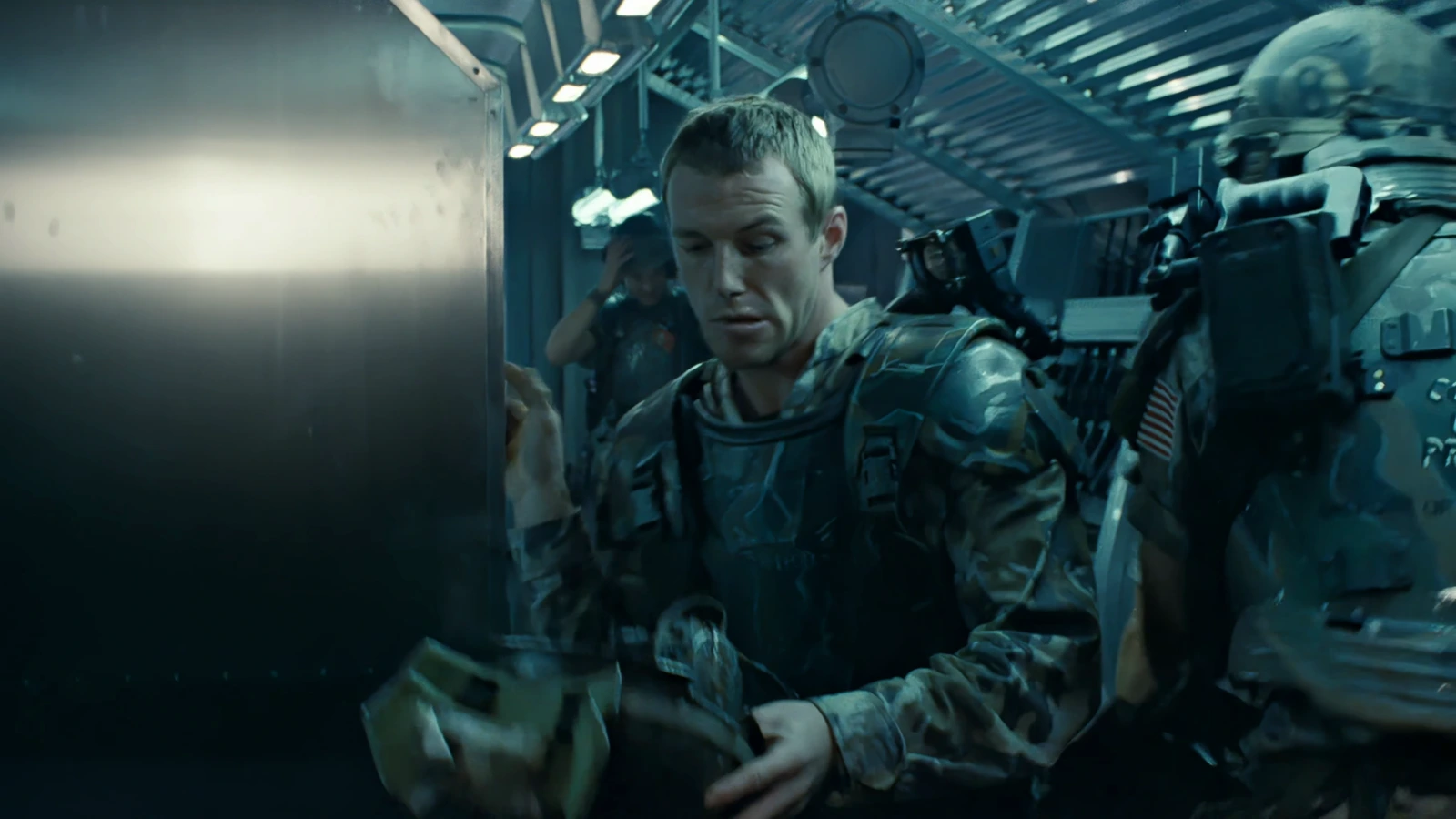 Private Tim Crowe in M3 armor holding his M10 helmet aboard the Sulaco in Aliens