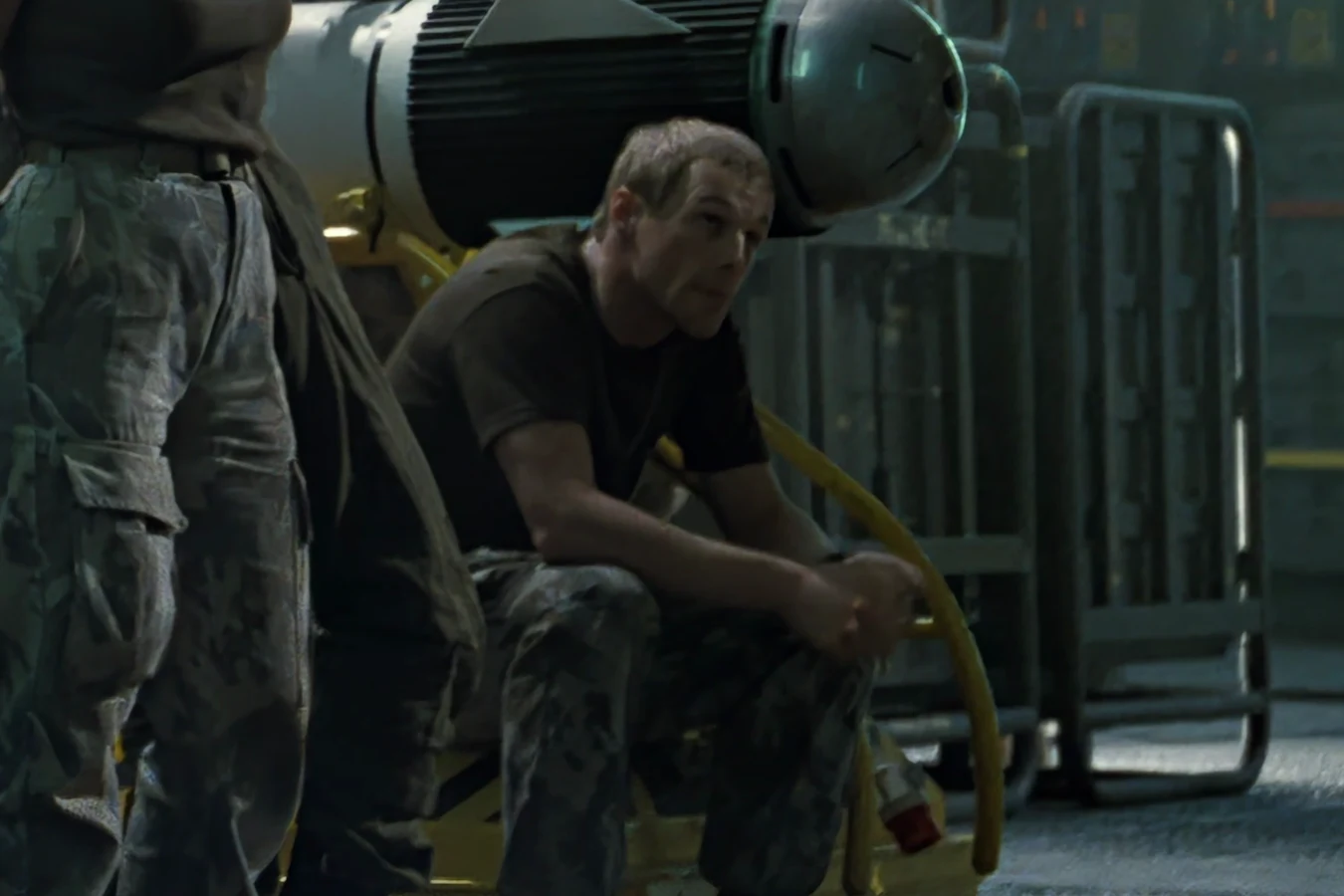 Tim Crowe sitting on the Sulaco hangar deck in a T-shirt and camouflage trousers in Aliens
