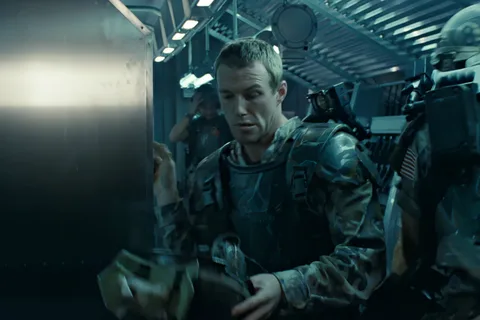Private Tim Crowe in M3 armor holding his M10 helmet aboard the Sulaco in Aliens