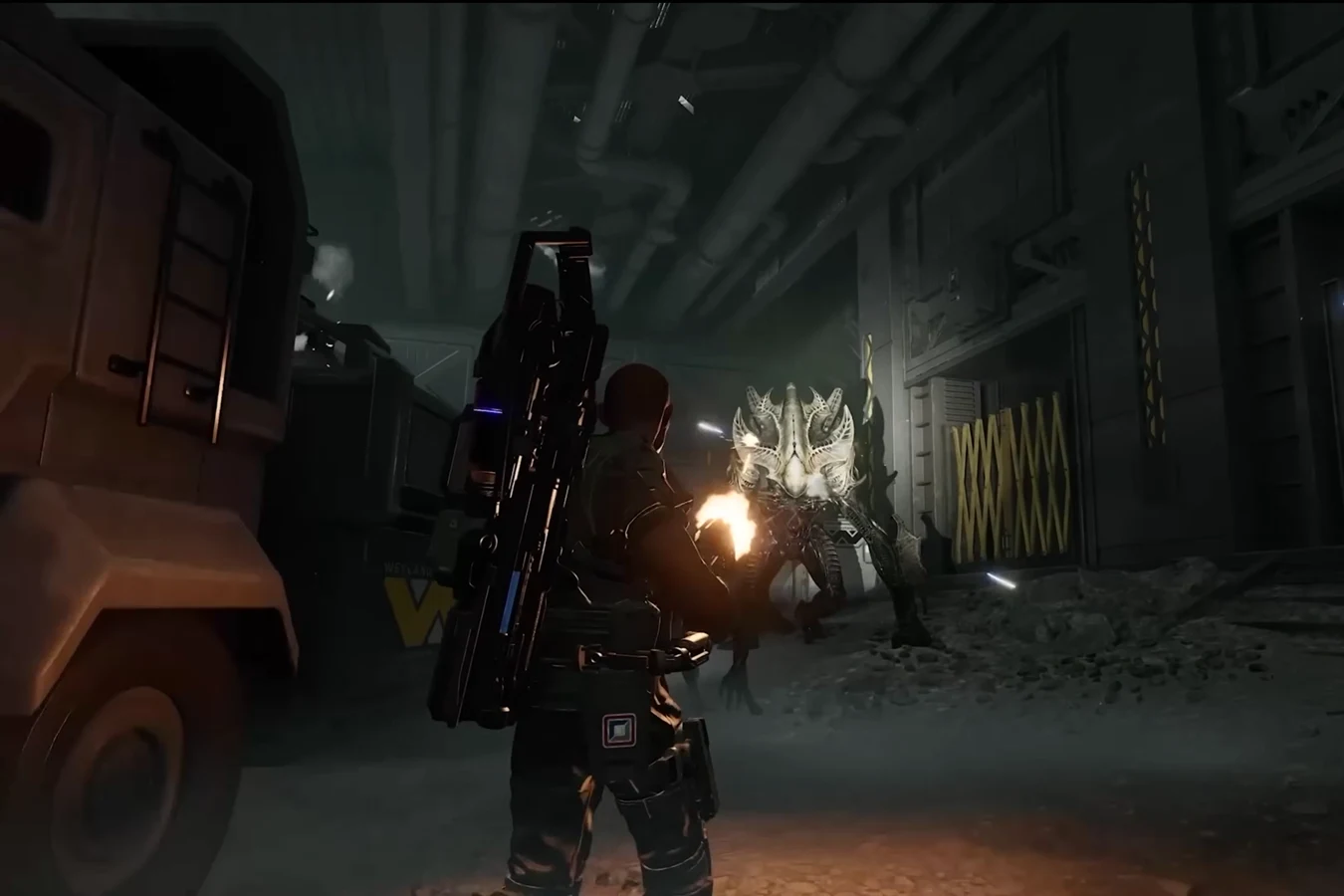 A Colonial Marine firing at a Warden Xenomorph in a cluttered industrial bay