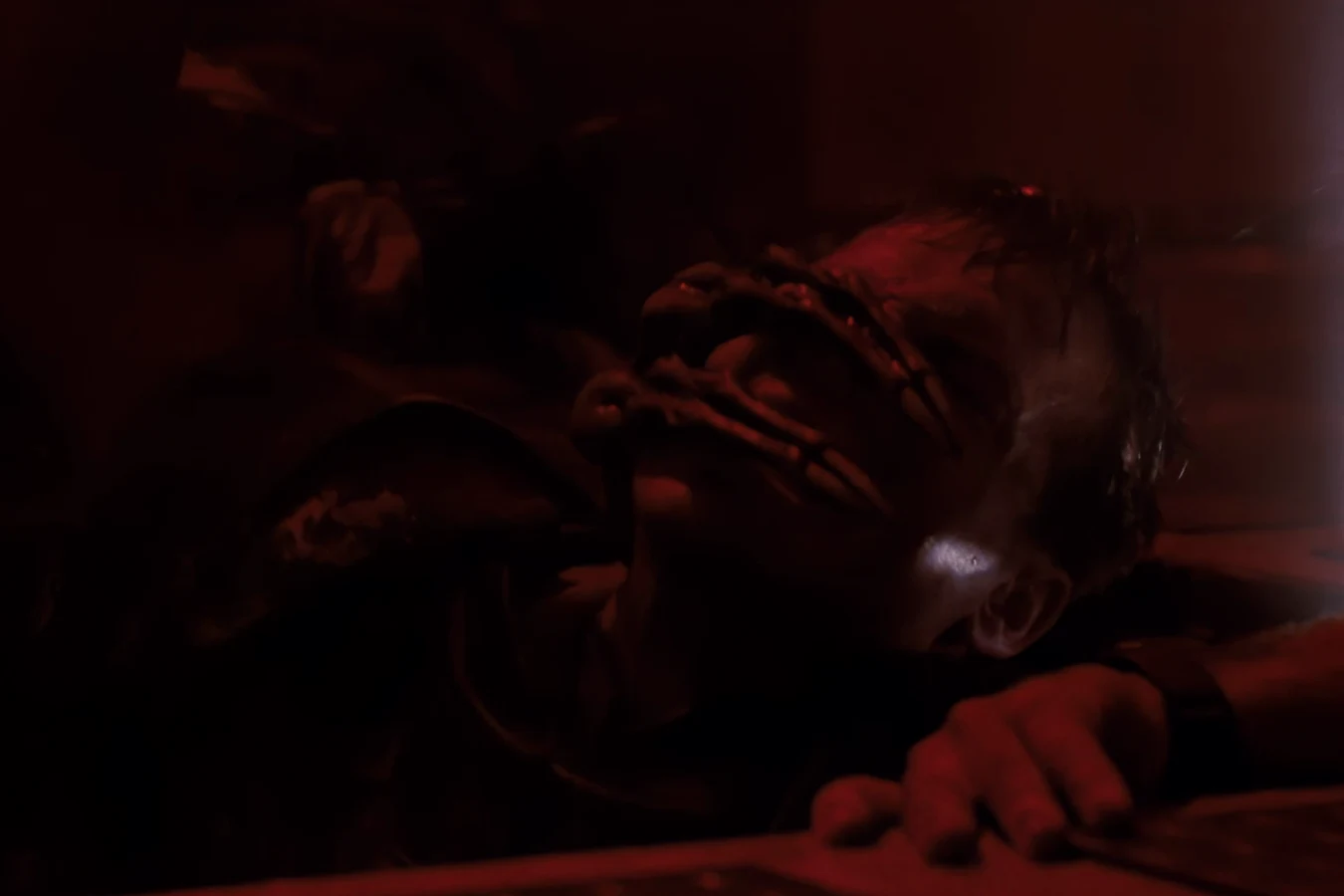A Warrior grabbing Hudson's face as it drags him under the Operations floor in Aliens