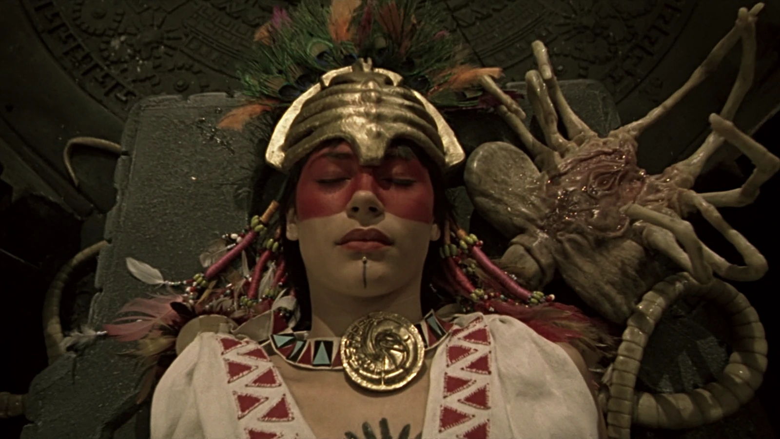 A ceremonial sacrificial woman lying beside a Facehugger