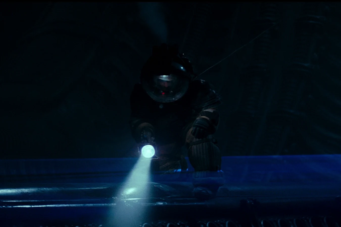 Kane looks down at a blue mist covering the Derelict egg chamber in Alien