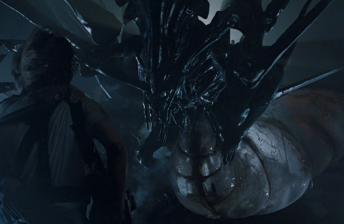 A Xenomorph Queen attached to her ovipositor while laying eggs