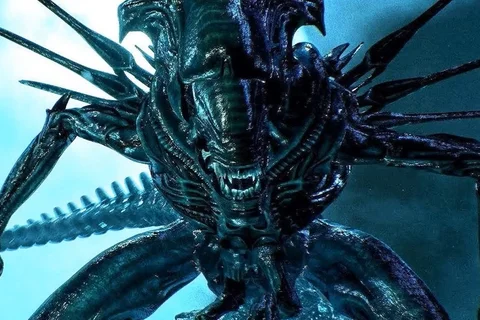 A Xenomorph Queen looming forward with jaws open and inner mouth exposed