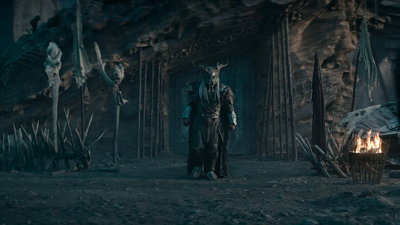 Njohrr standing on Yautja Prime beside a Predator building in Predator: Badlands