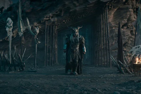 Njohrr standing on Yautja Prime beside a Predator building in Predator: Badlands