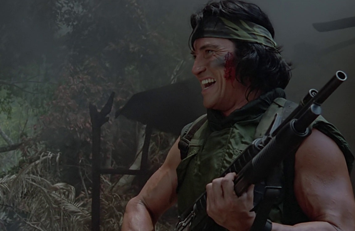 Billy from Predator laughing at a joke