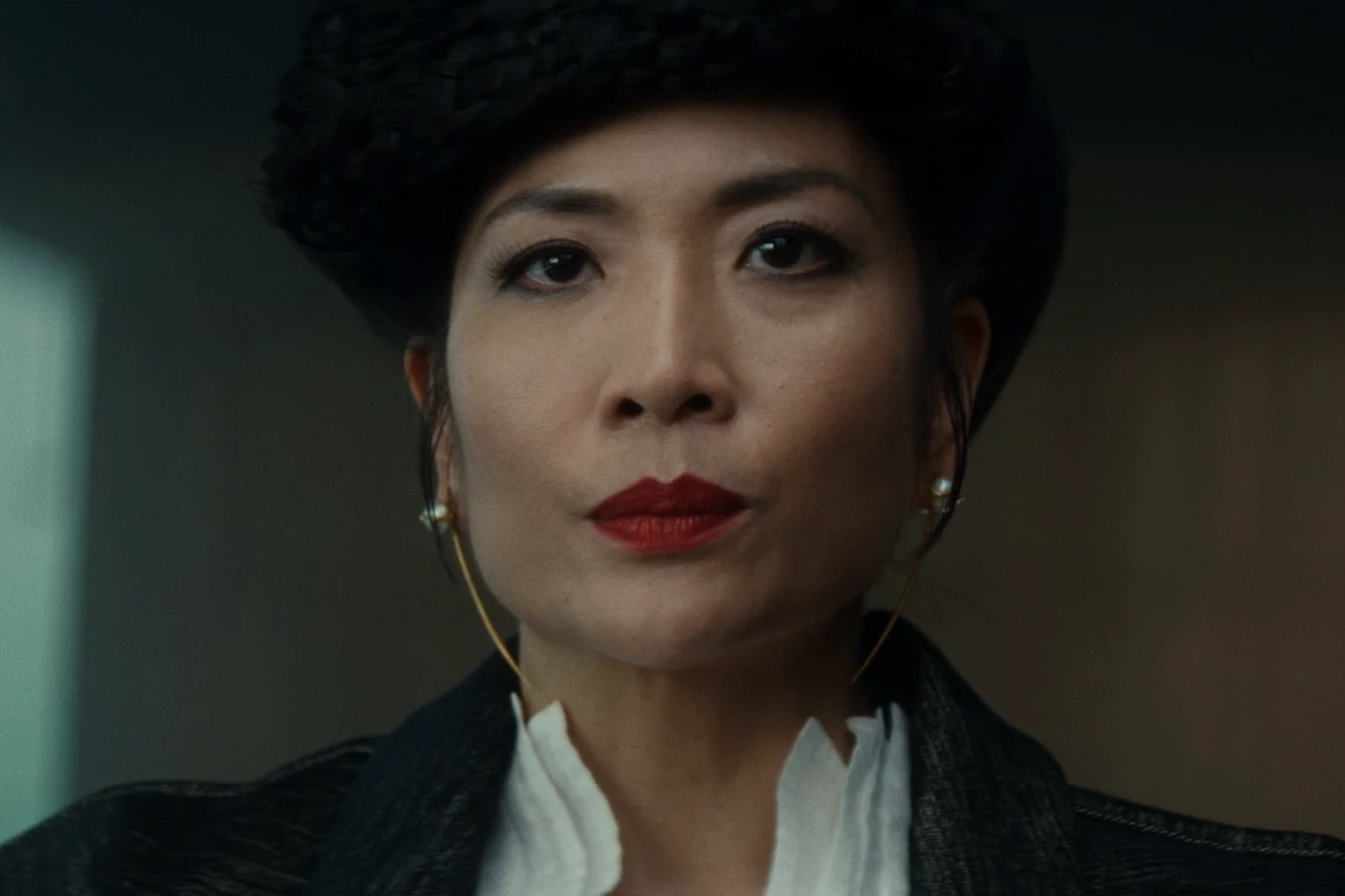 A close view of Yutani with red lipstick and a fur hat during the specimen negotiations in Alien: Earth